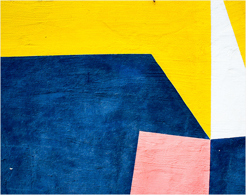 image of a painted wall with blue, yellow and pink geometric shapes